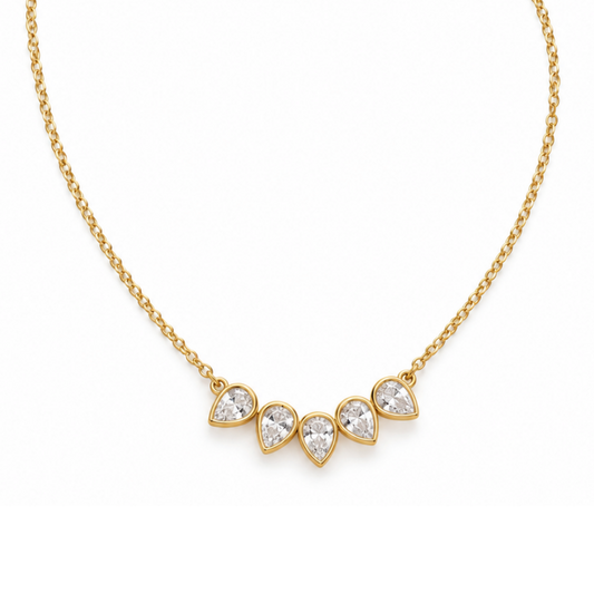 Petal Bezel Necklace by Julie Saldivia featuring five sparkling pear-shaped clear stones in 18K gold-plated 925 sterling silver, with a delicate adjustable chain from 15 to 18 inches, on a white background.
