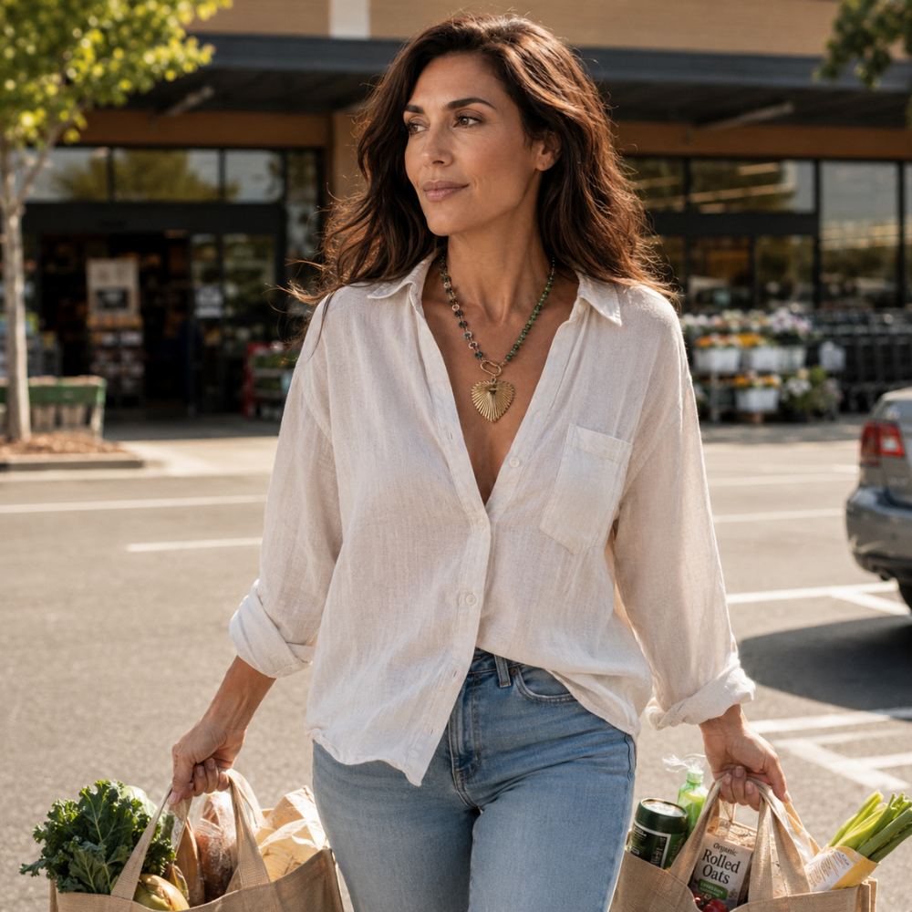 Woman wearing Radiance Heart 22 inch resin necklace with multicolor chain and 18k gold plated heart pendant while carrying grocery bags in daylight