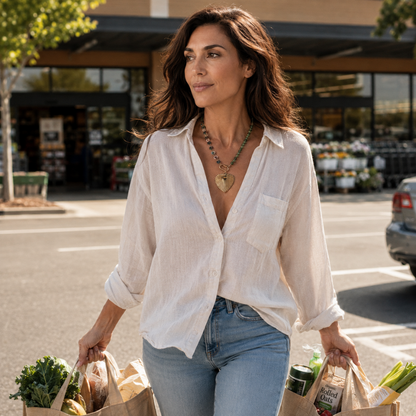 Woman wearing Radiance Heart 22 inch resin necklace with multicolor chain and 18k gold plated heart pendant while carrying grocery bags in daylight