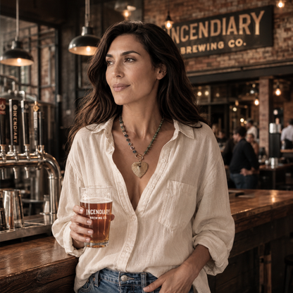 Woman wearing Radiance Heart resin necklace with multicolor chain and 18k gold plated heart pendant while standing at Incendiary Brewing in Greensboro NC