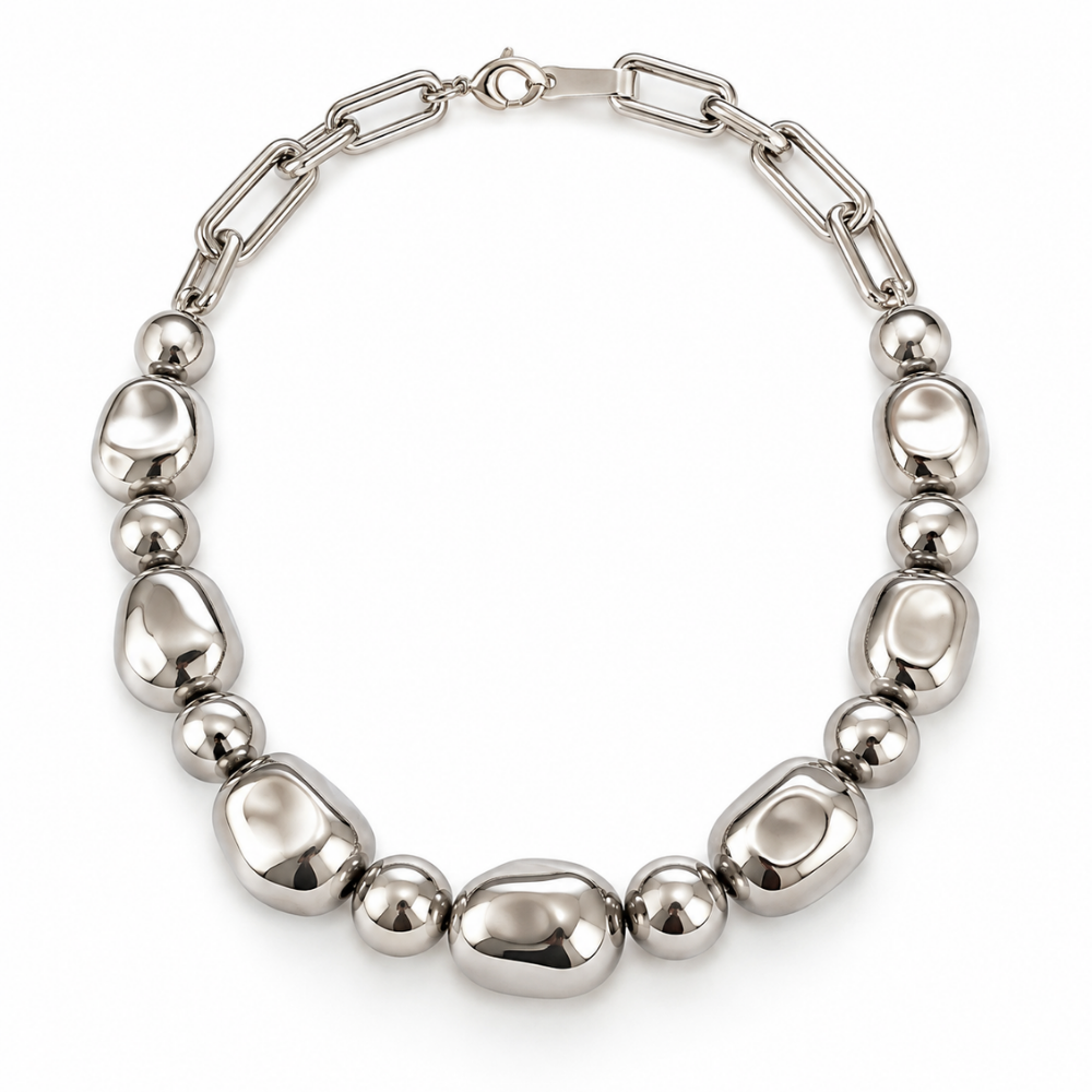 A polished silver-tone metal necklace featuring a combination of smooth oval beads and spherical beads connected by a paperclip chain, displayed on a clean white background.