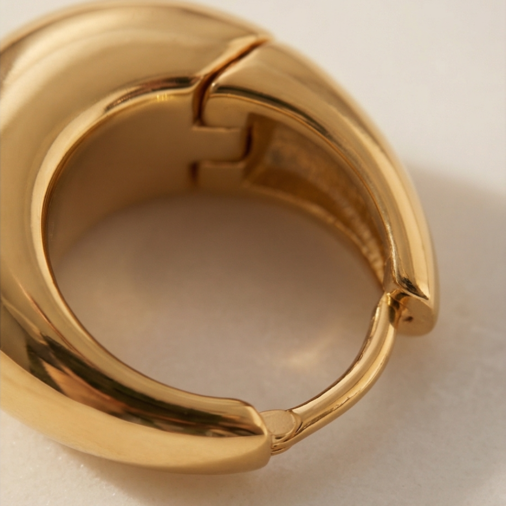 Gold hoop earring on a beige background