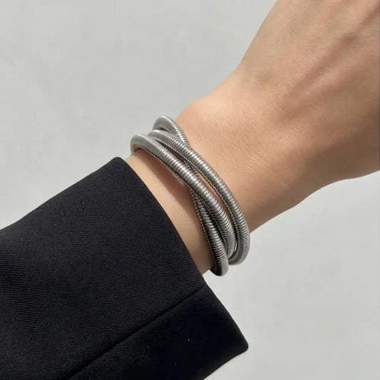 silver coiled wrap bracelet on wrist modern statement bracelet flexible metal jewelry for women
