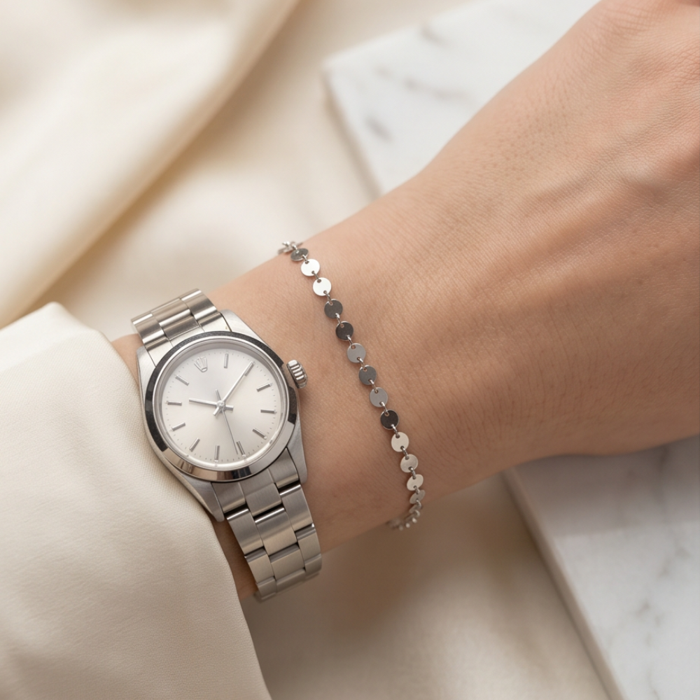 Silver disc permanent bracelet styled with a watch for an elegant everyday jewelry look.