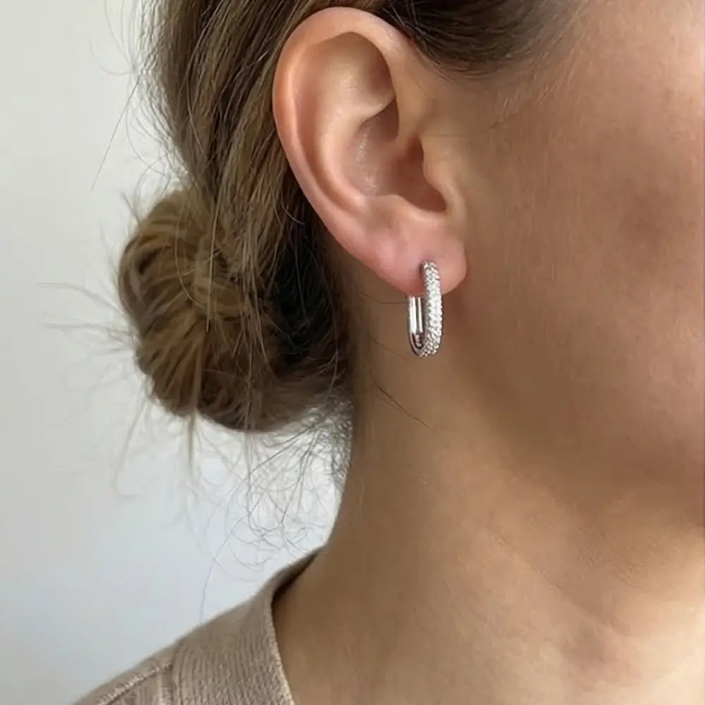 woman wearing silver huggie hoop earrings with cubic zirconia everyday elegant jewelry styling