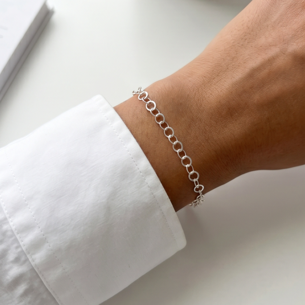 Silver link permanent bracelet worn on the wrist with a clean and minimal everyday style.