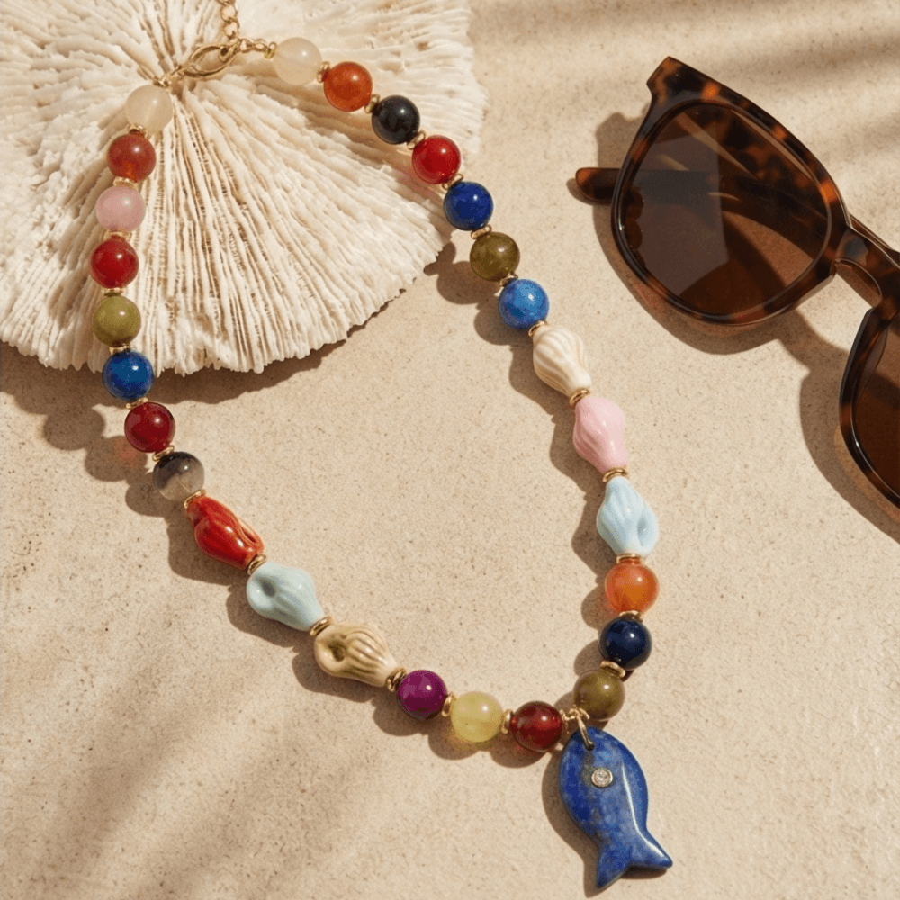 Colorful summer necklace with fish pendant styled with sunglasses beach aesthetic