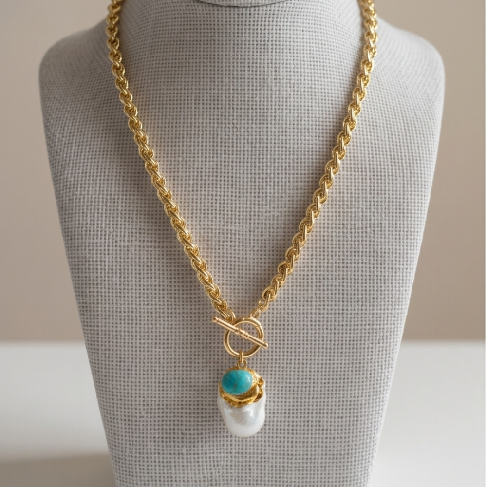 Gold toggle chain necklace with turquoise stone and baroque pearl pendant by Julie Saldivia styled on model and displayed