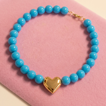 Turquoise blue beaded necklace with a polished gold puffy heart centerpiece by Julie Saldivia
